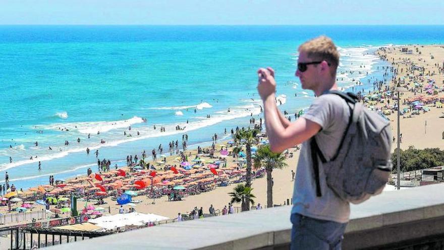 Un turista hace fotos en el paseo de Playa del Inglés, en el sur de Gran Canaria. | | ANDRÉS CRUZ