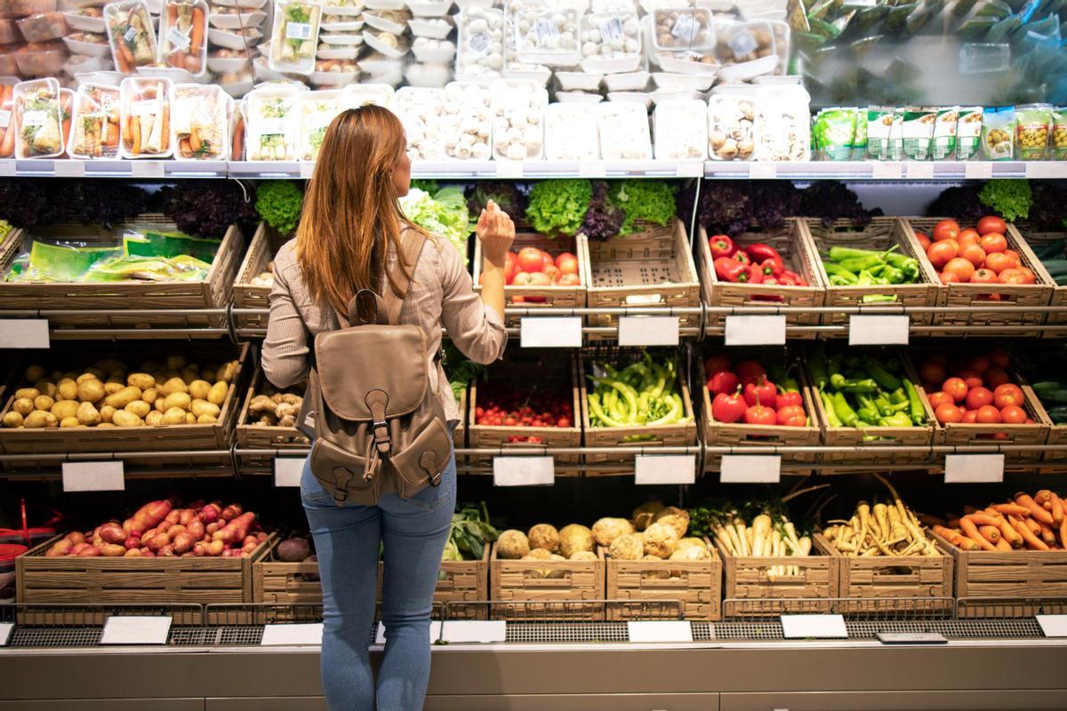 Una mujer en la sección de frutería del supermercado.