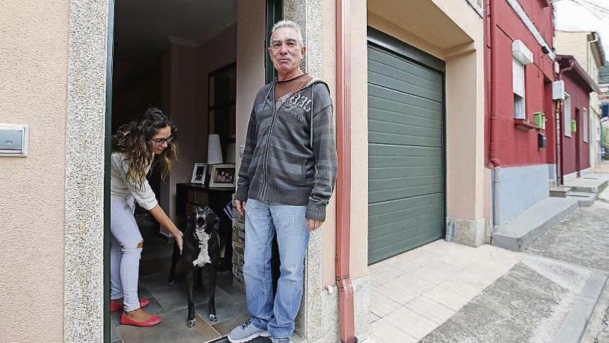 Guillermo, su hija y su perro en la puerta de su vivienda en Teis. // Marta G. Brea