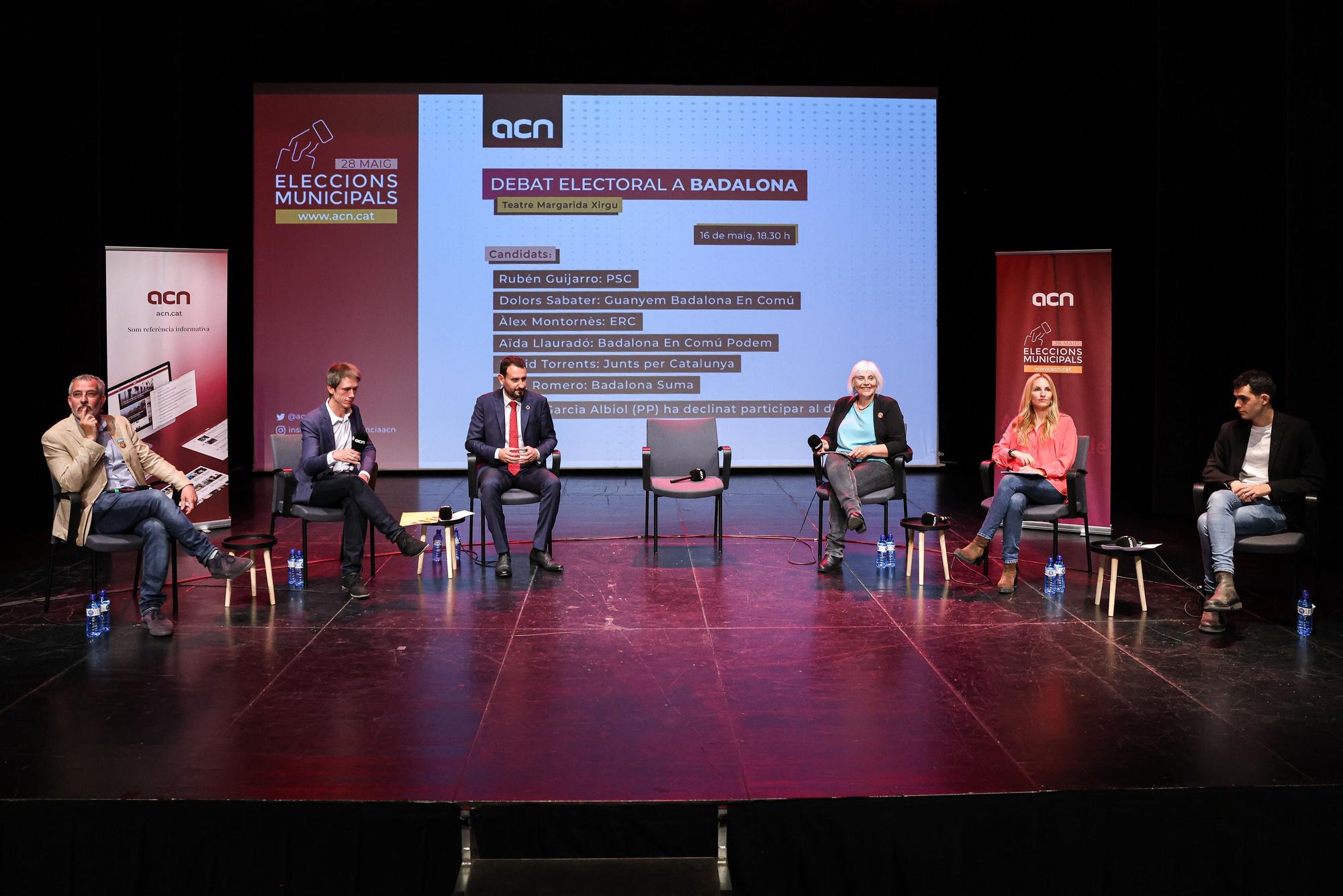 Los candidatos a la alcaldía de Badalona que han participado en el debate, y la silla vacía del ausente Albiol