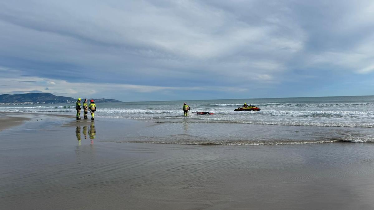 Los bomberos acuden a sacar el paracaídas del agua.