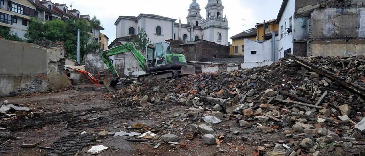 Arriba, la parcela tras el derribo de Casa Feito, con la iglesia de San Juan al fondo. A la izquierda, niños jugando ante el solar.