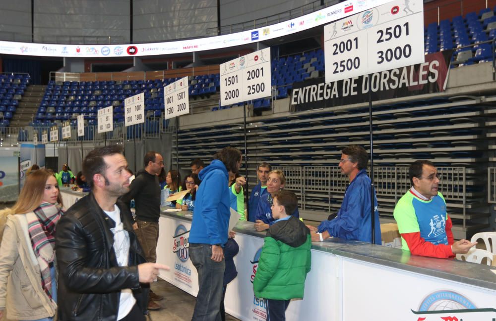 Los participantes de la Maratón recogen sus dorsales para la carrera del domingo