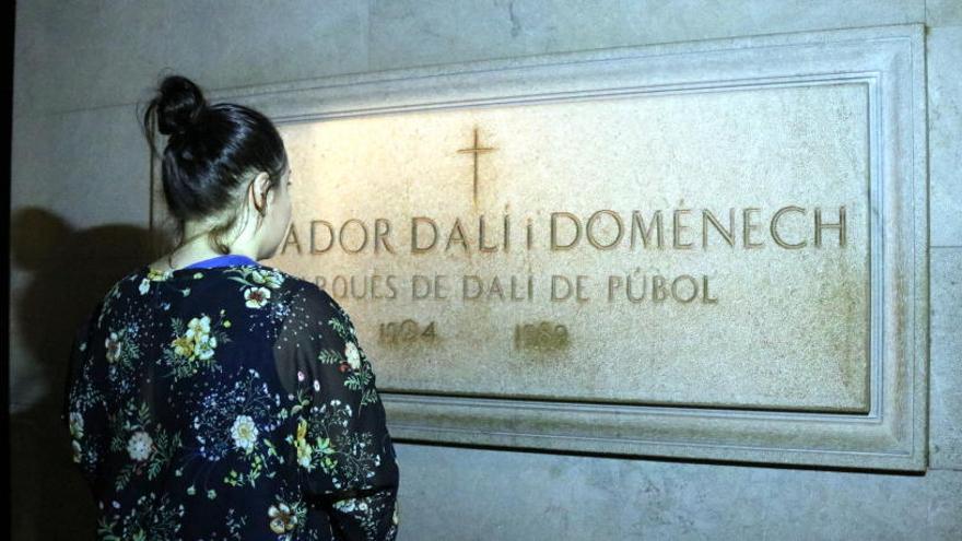 Una persona observant la làpida de Salvador Dalí.