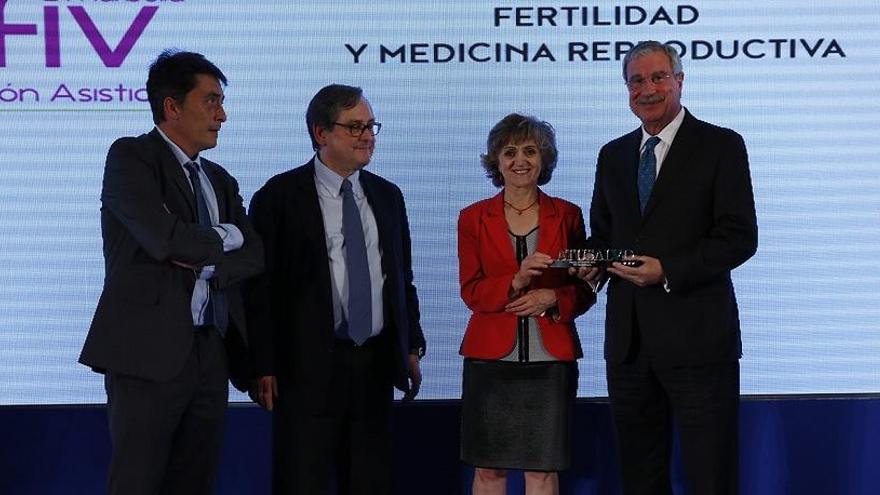 La ministra entrega el premio a representantes de la clínica.