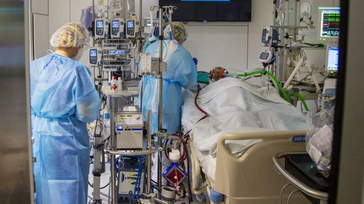 Un sanitario asiste a un enfermo de Covid-19, en la UCI del Hospital Clínic de Barcelona.