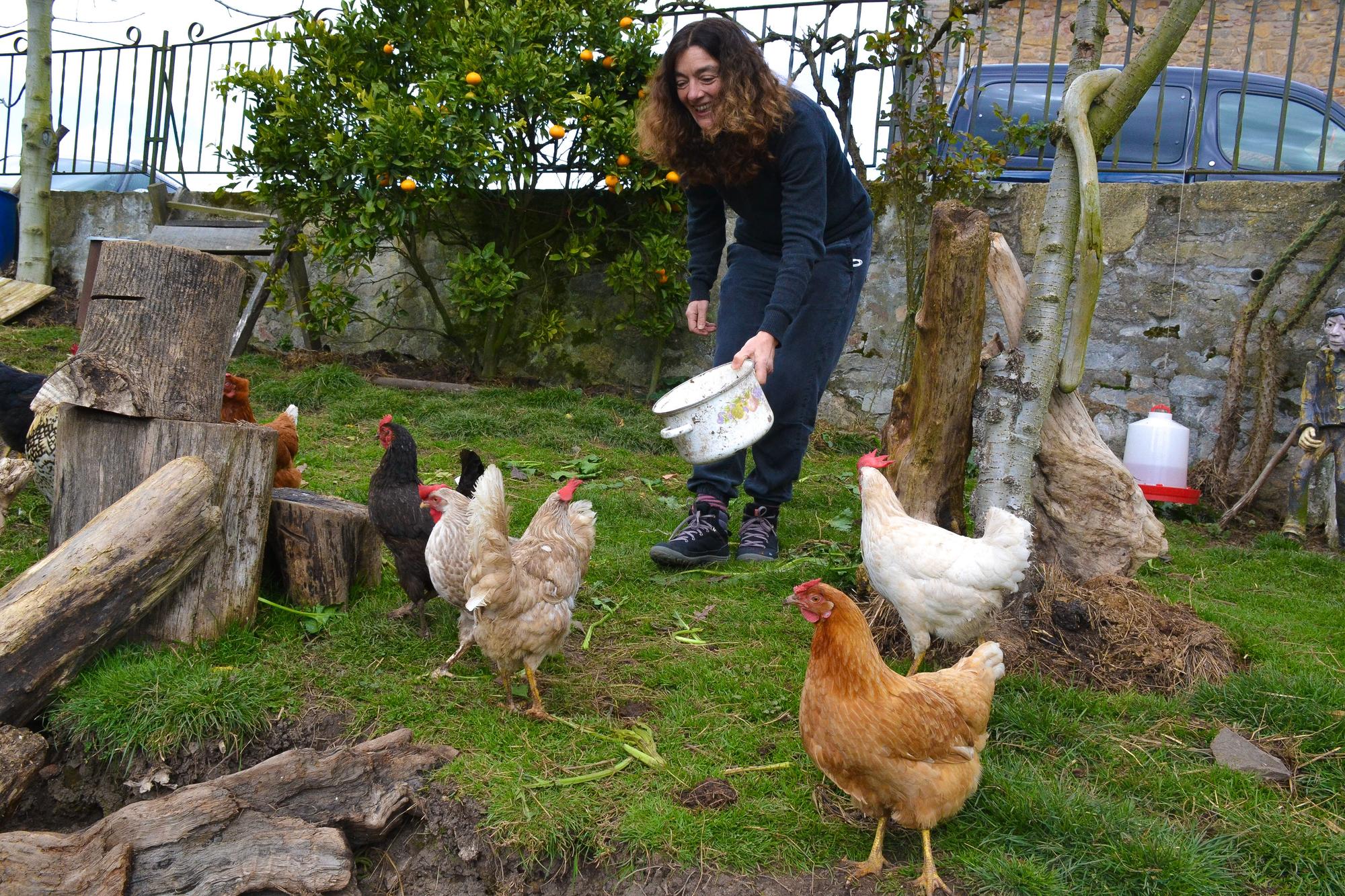 Andrea Martha Gordon da de comer a las gallinas que tienen en el huerto.