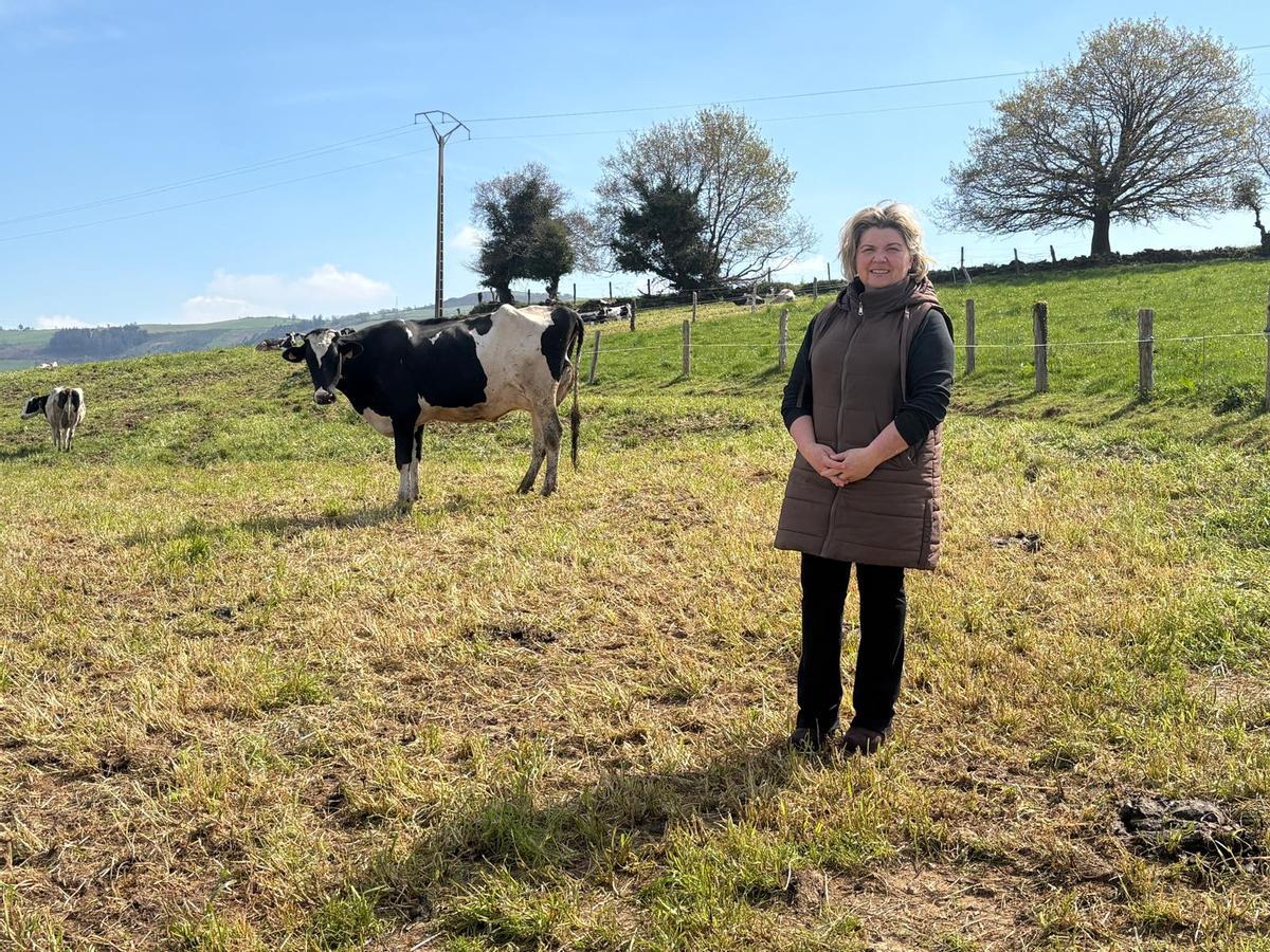 Rosa María López con sus vacas de fondo.