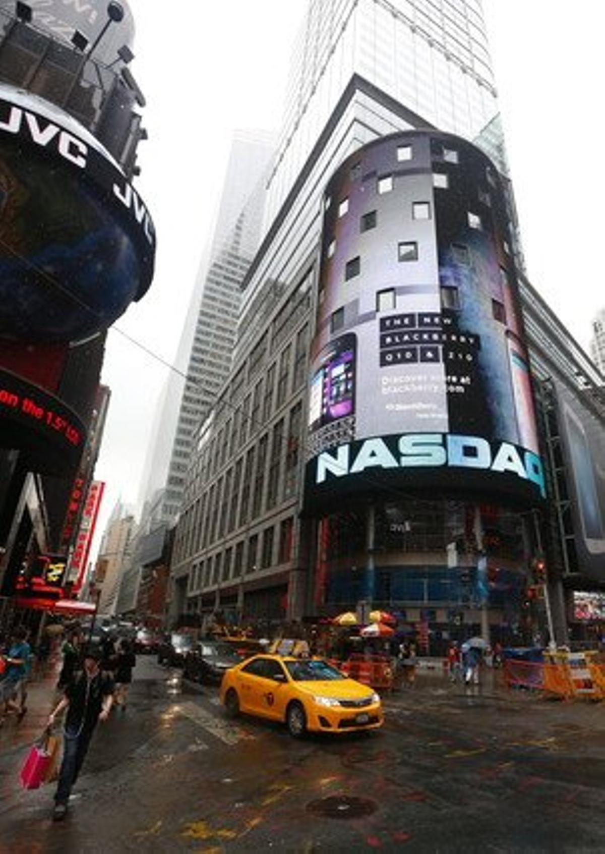 Un taxi passa davant de la seu del Nasdaq, a Nova York.