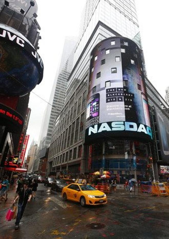 Un taxi passa davant de la seu del Nasdaq, a Nova York.