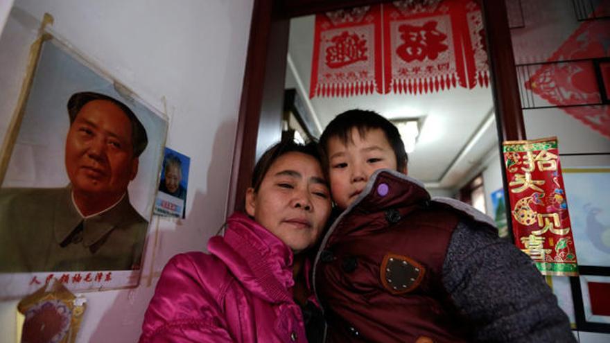 Mei Qiuyu (izda) y su hijo Wang Zhongsheng (dcha), de 5 años, posan en su casa