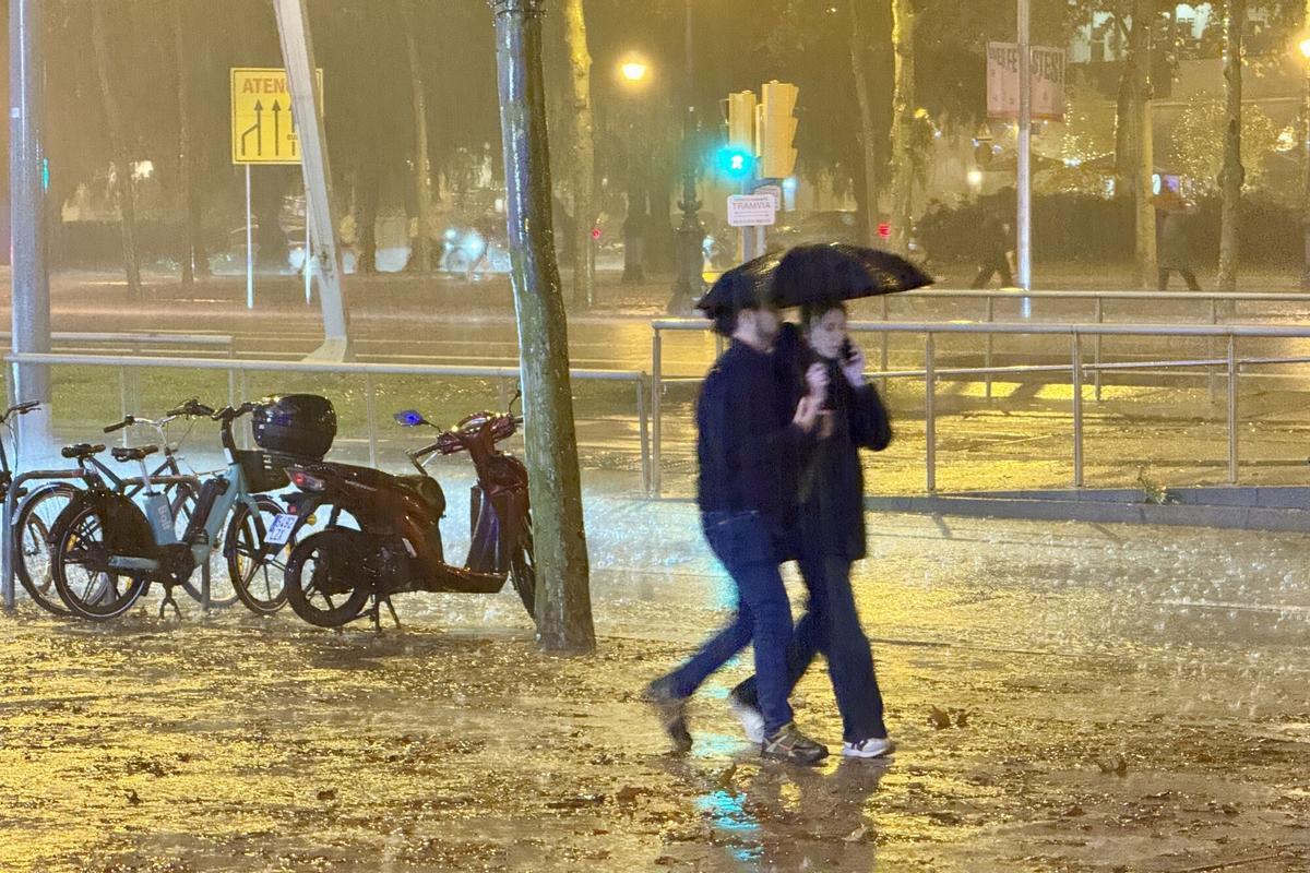 Una pareja en la lluvia a la altura de lIlla Diagonal, en Barcelona