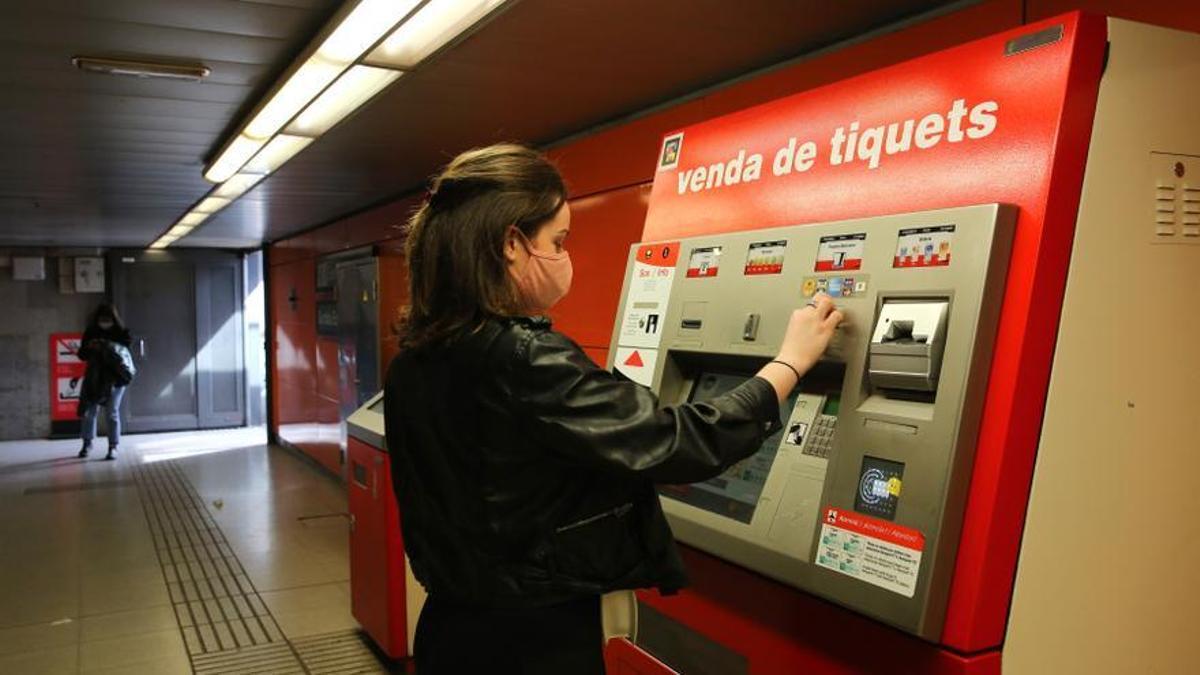 Una joven trata de adquirir un título de transporte en el metro de Barcelona