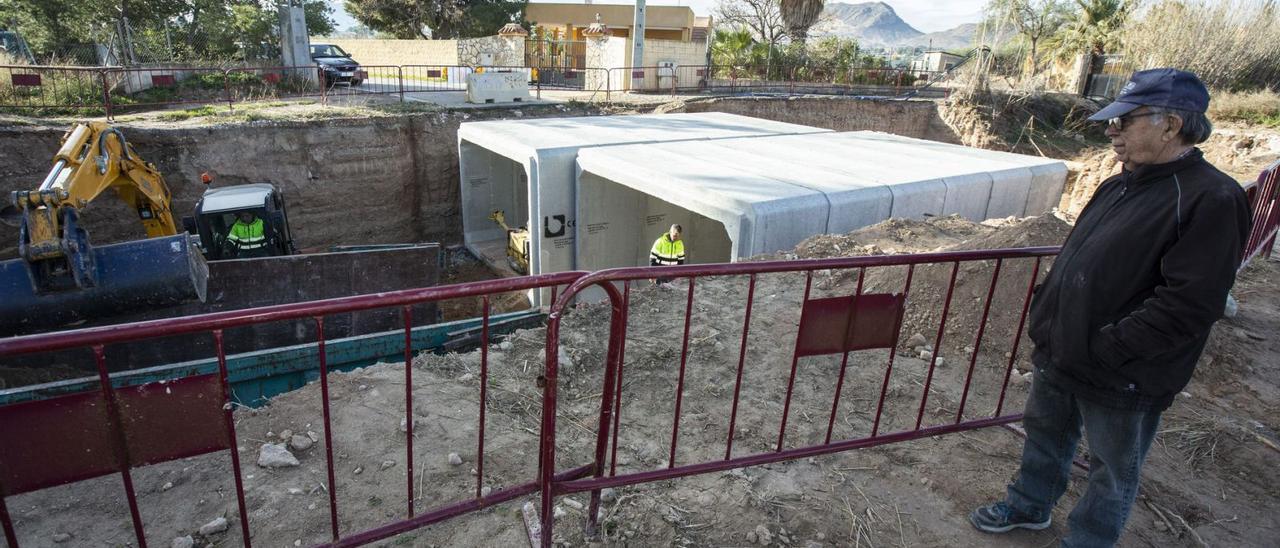 Un vecino observa las obras, que consisten en la instalación de hormigón y construcción de muros para canalizar las aguas pluviales. | ALEX DOMÍNGUEZ