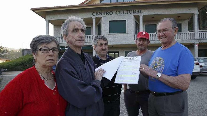 Mijón, en el centro, con los promotores de la campaña, ante el centro cultural, cerrado hace 10 meses. // R. Grobas