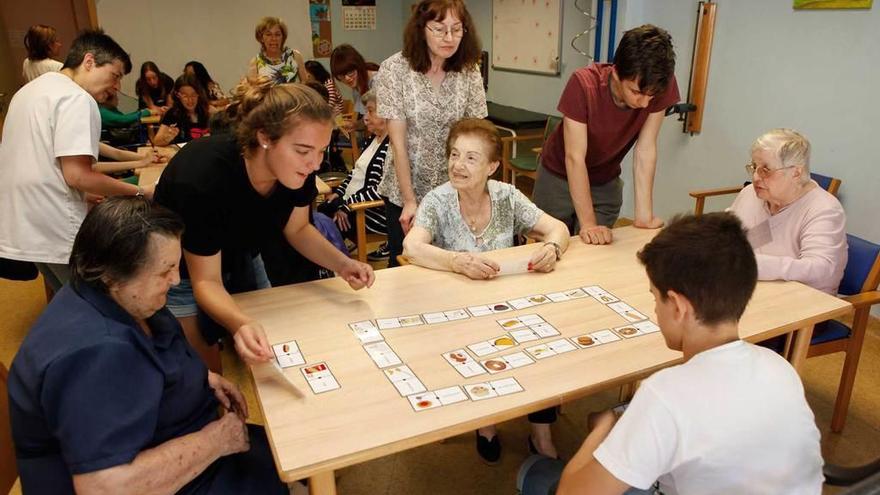 La estudiante Claudia García, enseñando a los mayores a jugar a una de las actividades, ayer, en el centro de día Clara Ferrer.