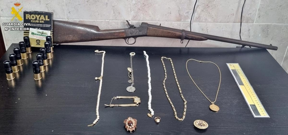 El arma y parte de las joyas recuperadas por la Guardia Civil.