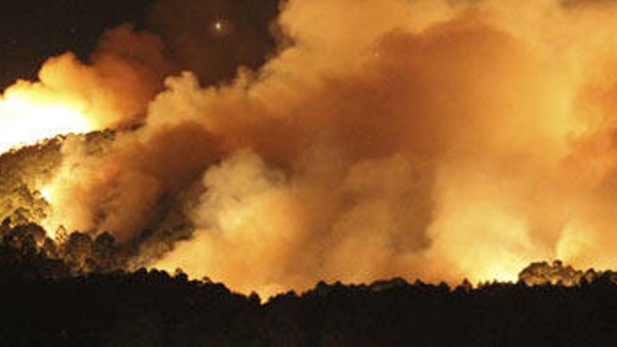 Vista del incendio forestal en los montes que rodean la parroquia de Baredo, en el municipio pontevedrés de Baiona, a primeras horas de hoy y que ya ha quemado unas 45 hectáreas. Tres helicópteros, un avión y otros medios terrestres, incluidos equipos de expertos, han sido movilizados para las labores de extinción del fuego, que en algunos casos ha estado cercano a zonas habitadas.de Baiona. //