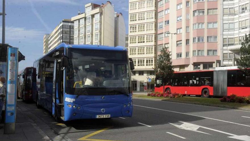 Un bus metropolitano, en primer término, en una parada en Os Castros.