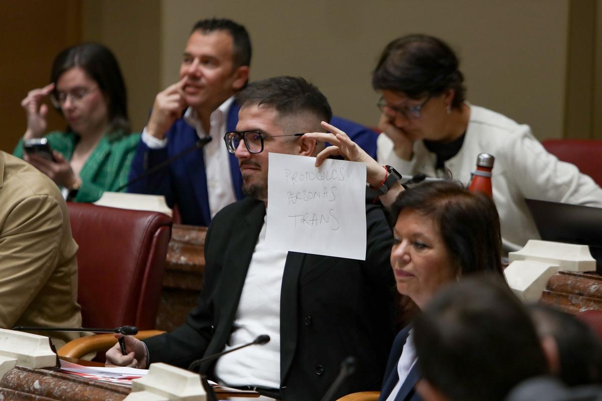 El diputado Miguel Ortega muestra un cartel a la consejera Conchita Ruiz.