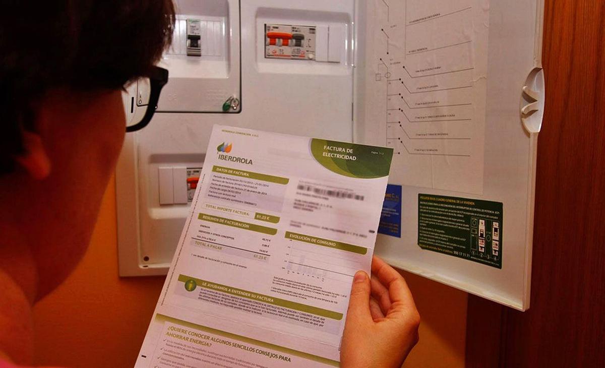 Una dona consulta una factura al costat del seu comptador. | JAVIER DE LA FUENTE