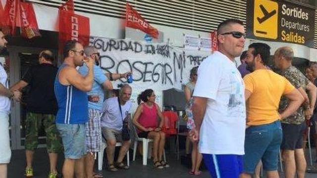 Los vigilantes de seguridad en huelga, ayer al mediodía en la entrada del aeropuerto.