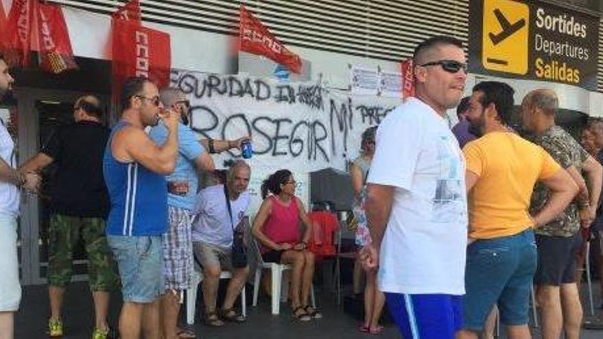 Los vigilantes de seguridad en huelga, ayer al mediodía en la entrada del aeropuerto.