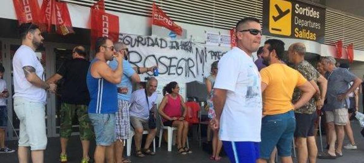 Los vigilantes de seguridad en huelga, ayer al mediodía en la entrada del aeropuerto.