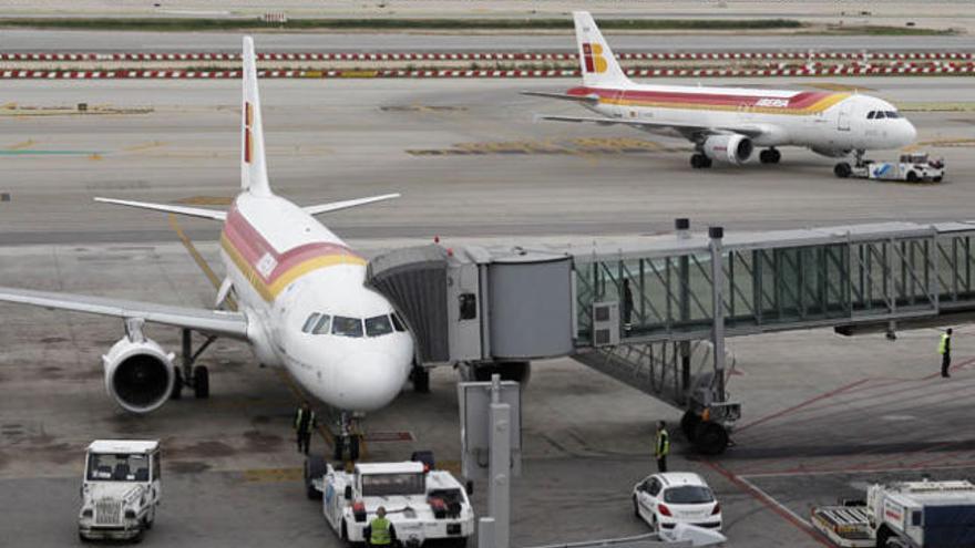 Imagen de aviones de la compañía Iberia  ayer en el aeropuerto de El Prat, en Barcelona, siendo atendidos por personal de tierra. | efe
