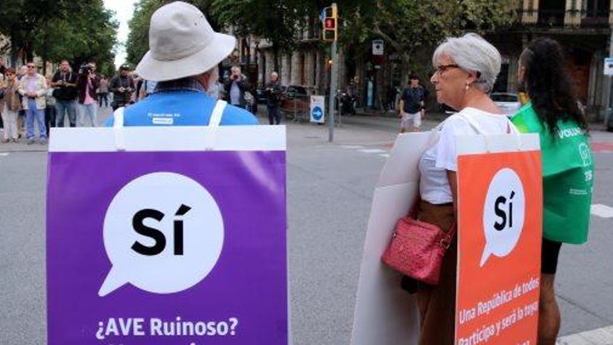 Dues persones que porten a sobre cartells a favor del sí, a Barcelona