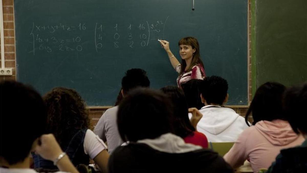 Una docente imparte clases en un aula.