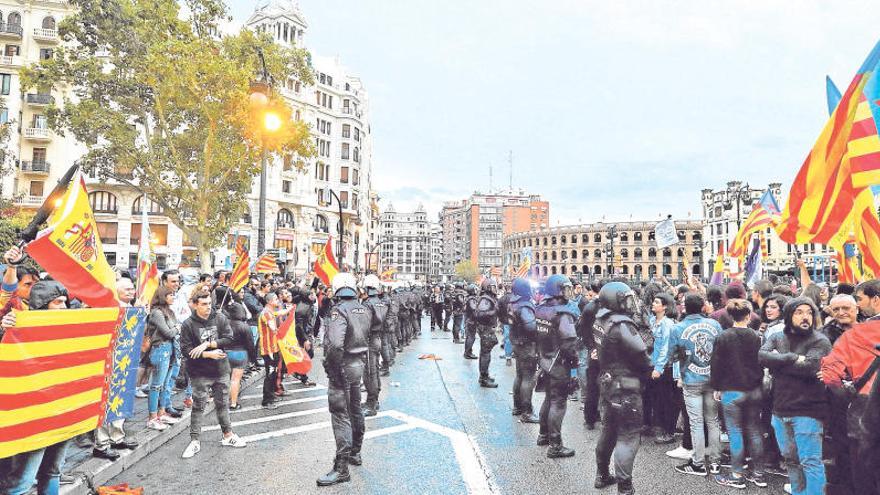 Dos cordones policiales separan a grupos ultras de los participantes en la manifestación de la Comissió 9 d´Octubre.