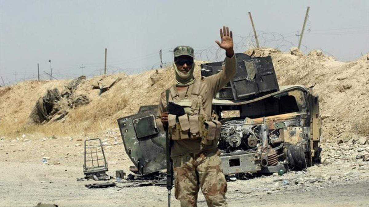 Un soldado iraquí posa ante un vehículo blindado destruido perteneciente al Estado Islámico cerca de Amerli (Irak).