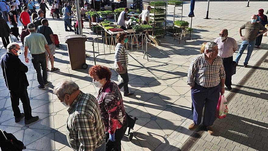 Clients del mercat fent cua per comprar a les parades.