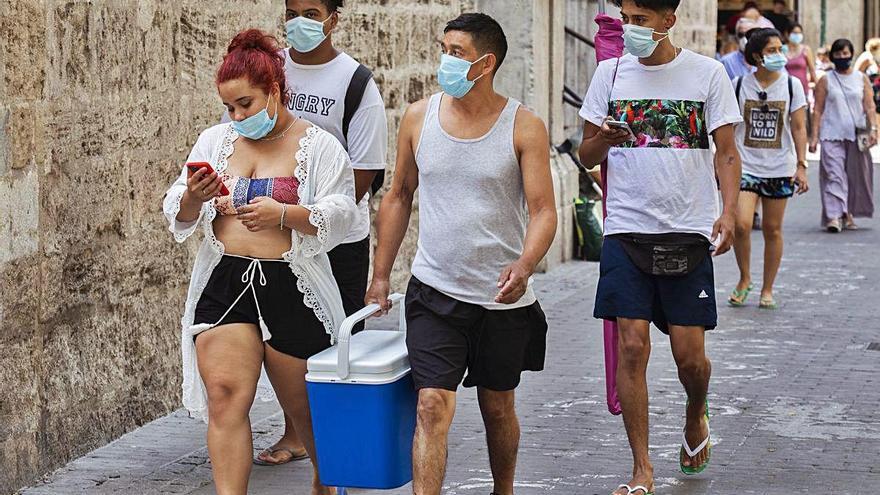 Un grupo pertrechado para ir a la playa, ayer, en el centro de València.