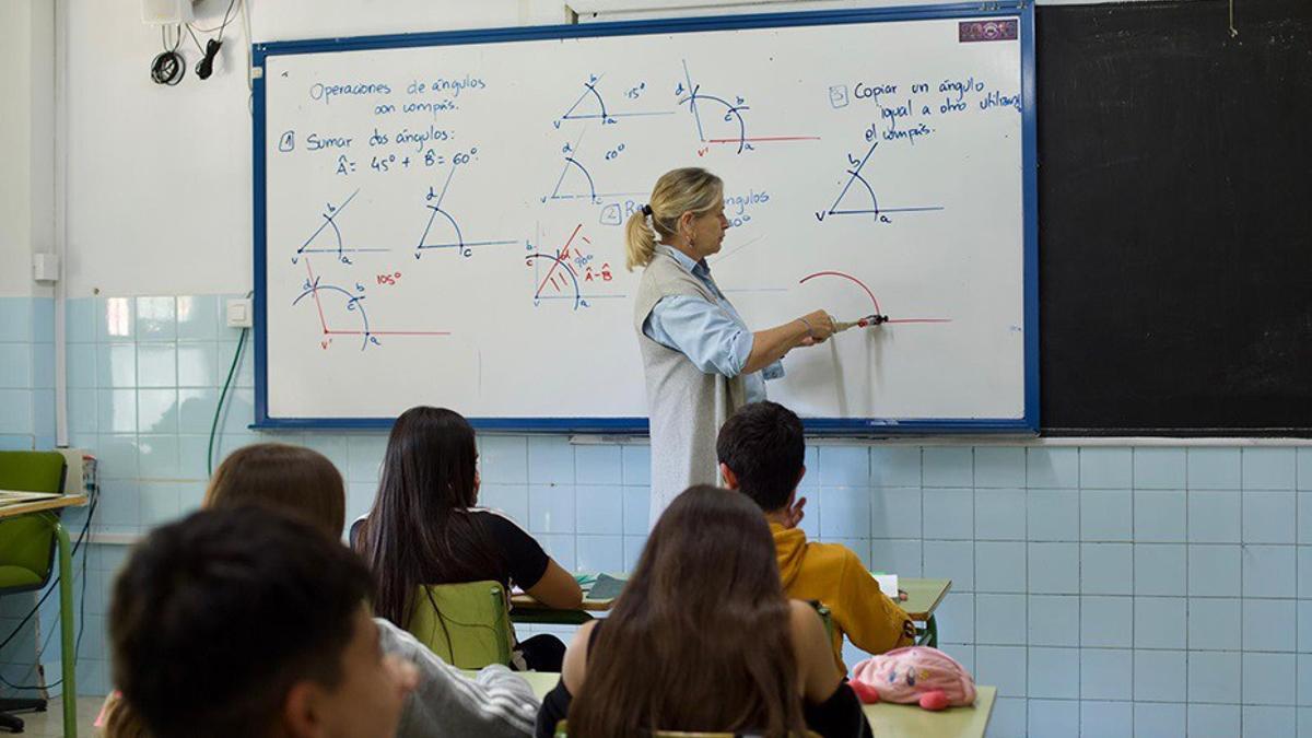Una profesora imparte clase a alumnos en un aula