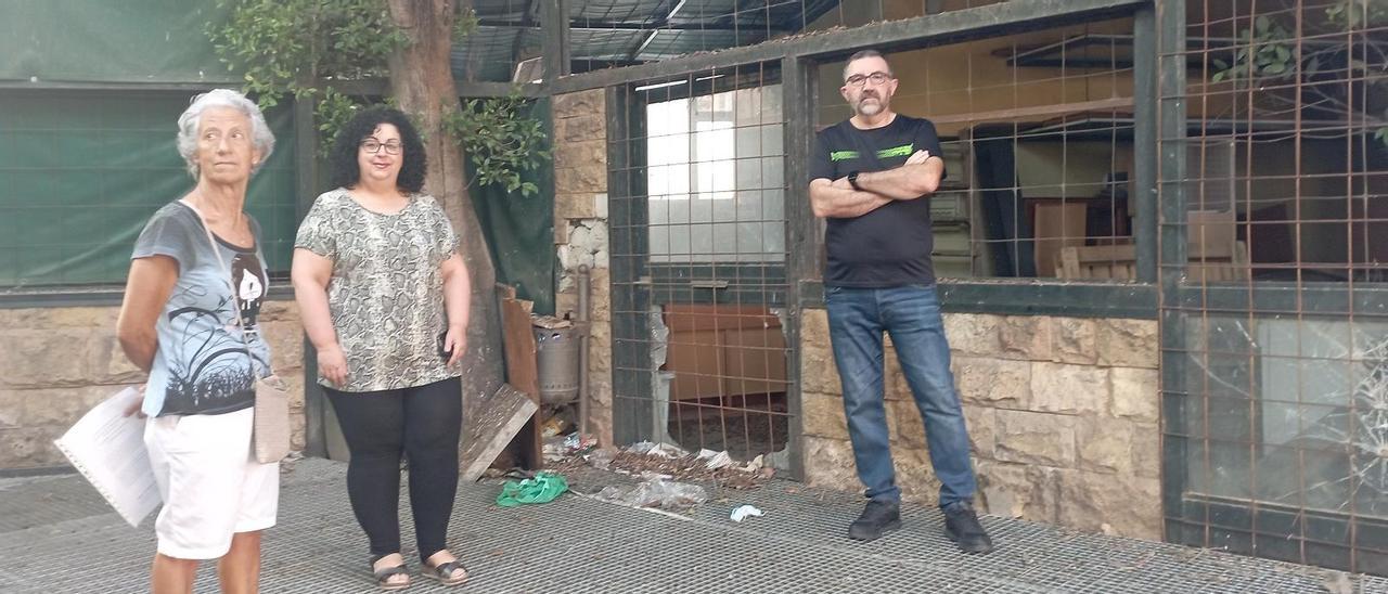 Vecinos de la parcela situada al pie de su bloque, junto a una nave apedreada y con basura acumulada en una esquina, el pasado miércoles.