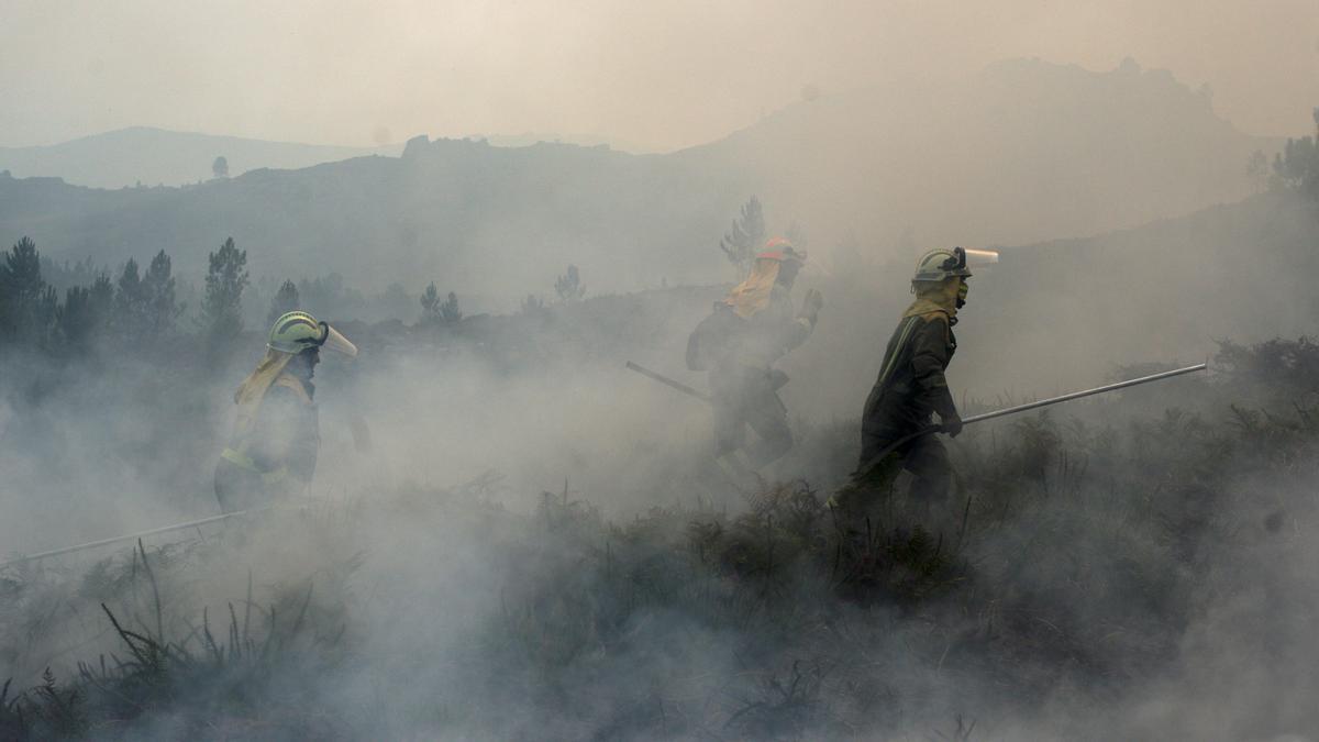 Una brigada, en la extinción entre el humo de un incendio en el Xurés en 2022.