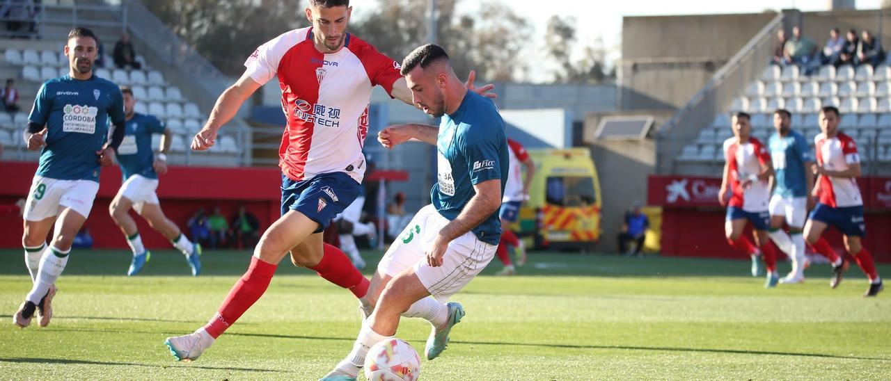 Carlos Puga protege el balón ante Roni durante el encuentro entre el Córdoba CF y el Algeciras, en el Nuevo Mirador.