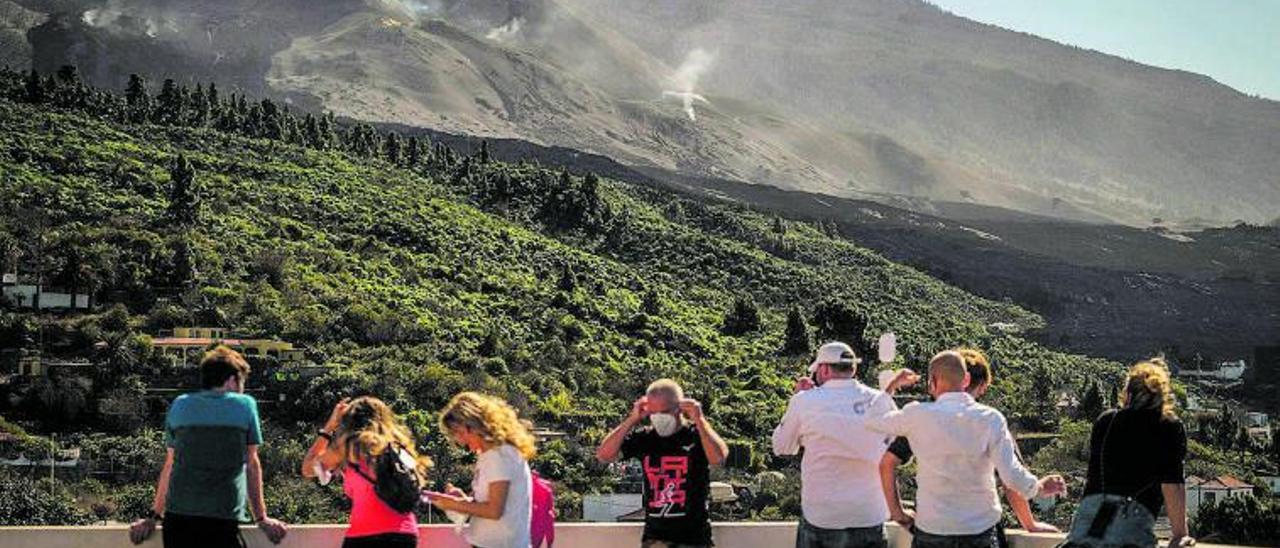 Curiosos acuden a un mirador para observar la erupción del volcán de La Palma.