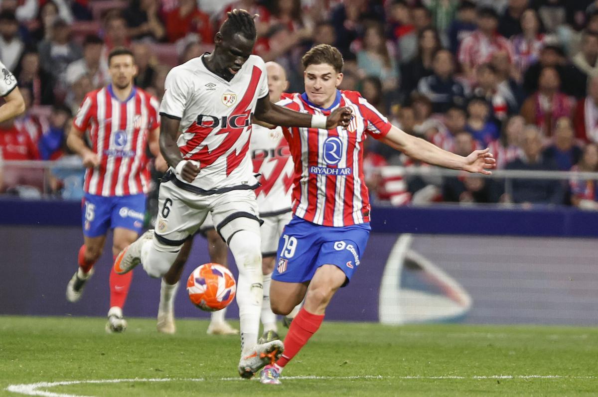 MADRID, 24/04/2025.- El delantero del Atlético Julián Álvarez (d) pelea un balón con Pathé Ciss, del Rayo, durante el partido de la jornada 33 de LaLiga EA Sports que Atlético de Madrid y Rayo Vallecano disputan este jueves en el estadio Metropolitano. EFE/Sergio Pérez