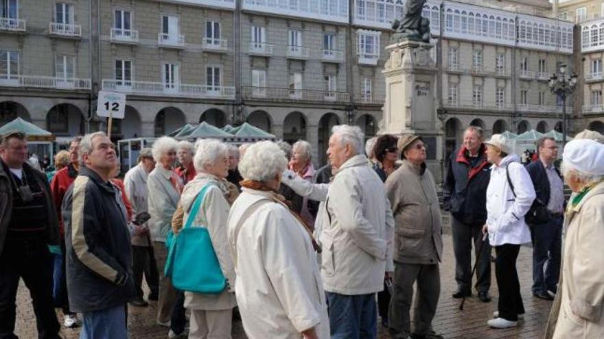 Turistas extranjeros llegados en varios cruceros visitan la plaza María Pita de A Coruña. / víctor echave