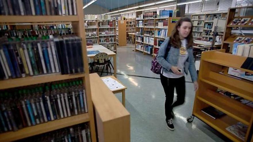 Una usuaria deja la biblioteca de Luanco.