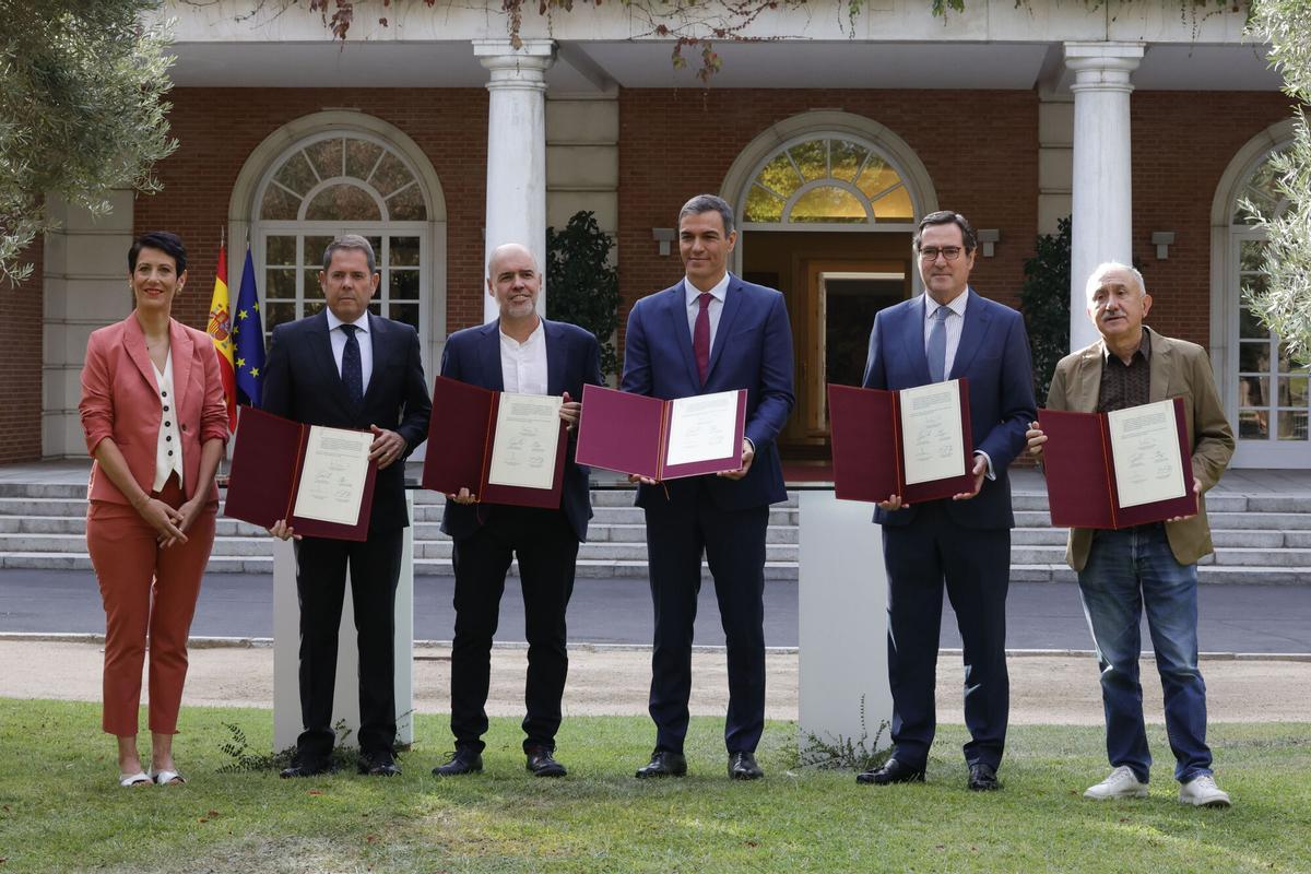 El presidente del Gobierno, Pedro Sánchez (c), posa con los representantes de la patronal y los sindicatos durante la firma del nuevo acuerdo en materia de pensiones.