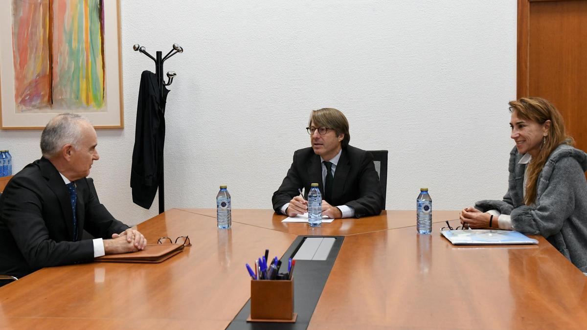 El conselleiro de Facenda (centro) junto al decano del Colegio Notarial de Galicia.