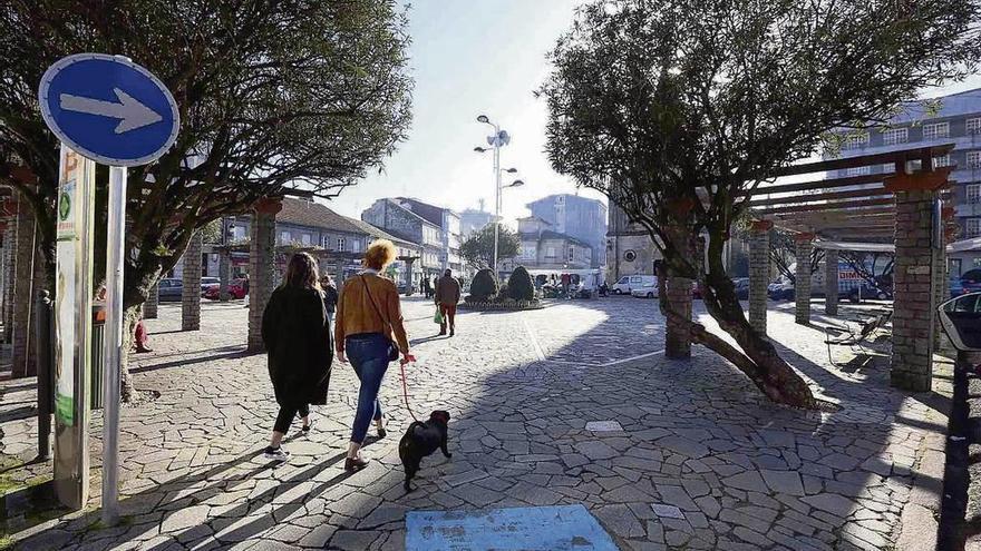 Unos vecinos pasean por la plaza de Bugallal de Ponteareas. // A. Hernández