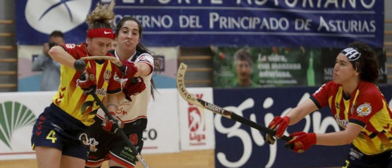 Nara López y Nuria Almeida disputan una bola elevada ante la mirada de Anna Casarramona. | Marcos León