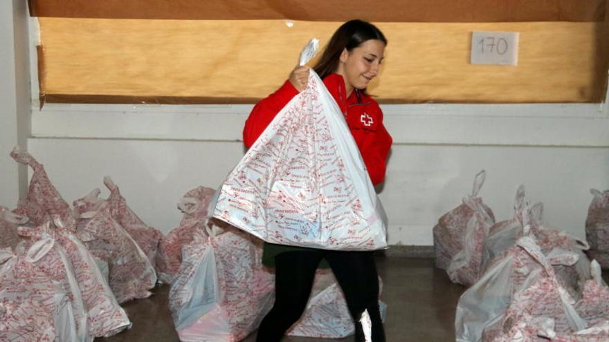 La directora de Joventut de la Creu Roja a Girona, Núria Prat, carregant un paquet de joguines