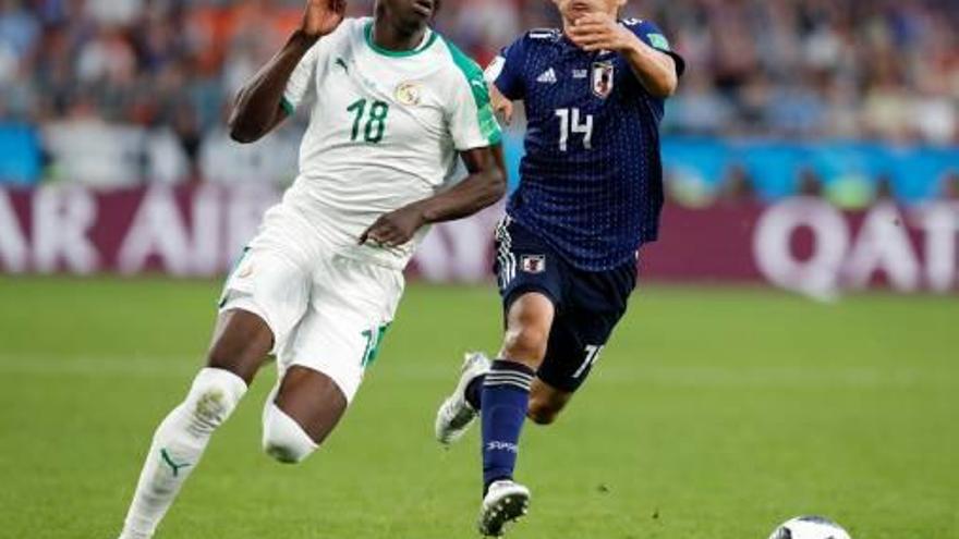 El senegalès Sarr i el japonès Inui lluiten per la pilota