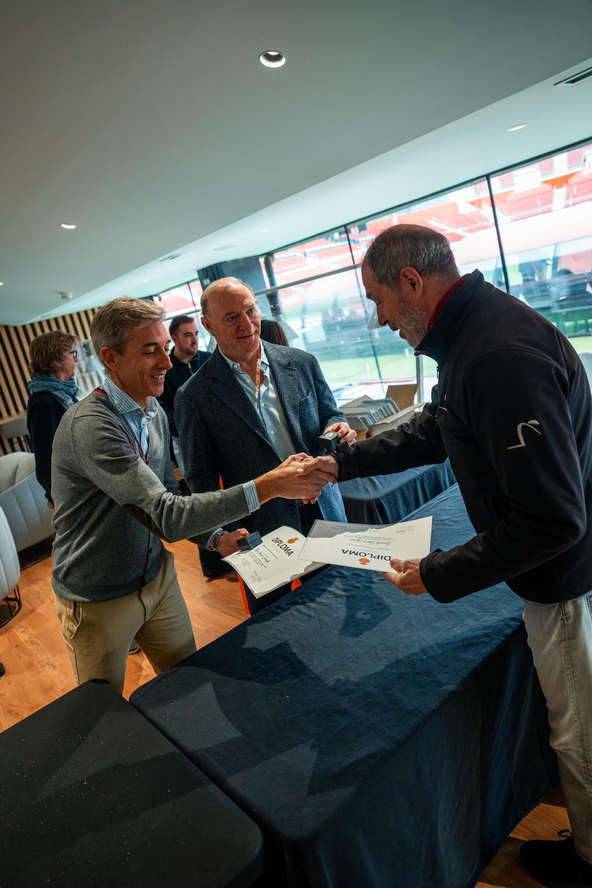 El presidente del Mallorca, Andy Kohlberg y el CEO Corporativo, Alfonso Díaz, entregan el diploma a un abonado.